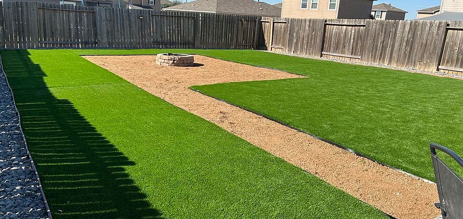 Backyard with artificial turf installation and fire pit