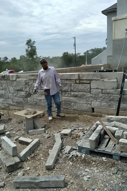 Mason finishing a stone retaining wall on site