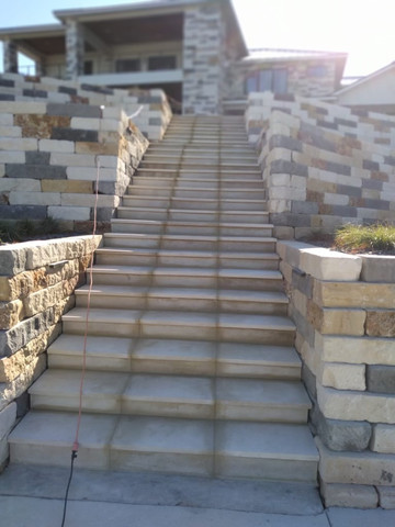 Stone staircase and retaining walls leading to a home