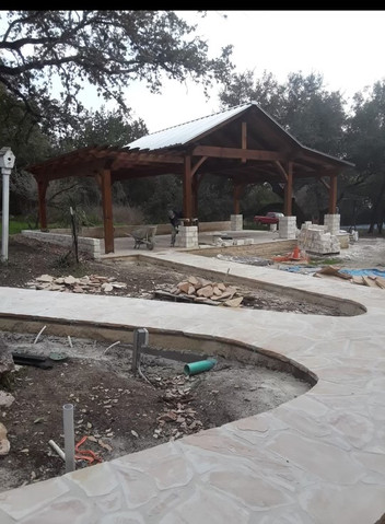 Large stone patio with pergola pavilion and retaining walls